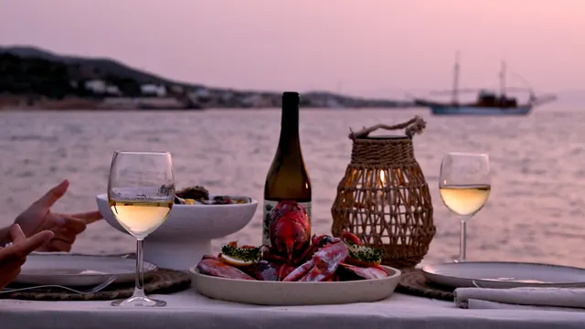 Wine and a fruit platter by the sea at sunset